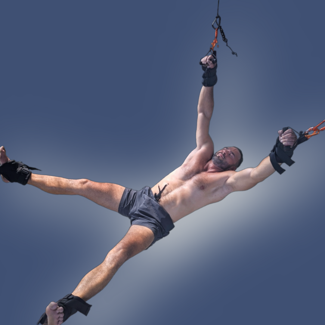 Pravilo therapy session with a man suspended in a wide X-pose, promoting full-body opening and flexibility.